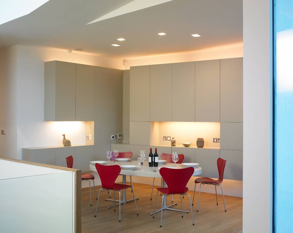 Ispirazione per una sala da pranzo moderna con pareti bianche e pavimento in legno massello medio