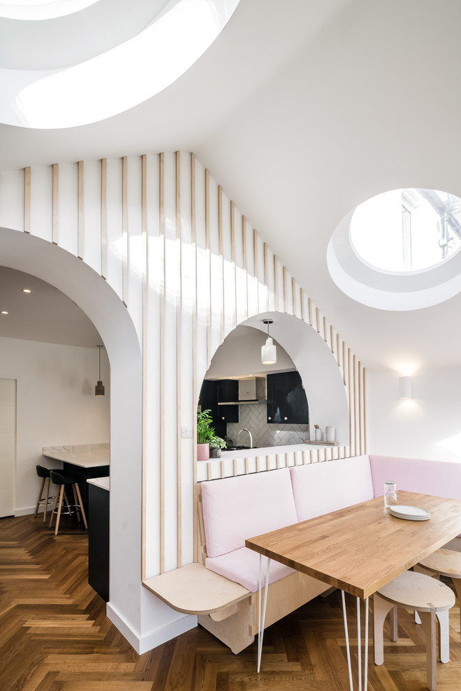 Idee per una sala da pranzo aperta verso il soggiorno tradizionale di medie dimensioni con pareti bianche, pavimento in legno massello medio e pavimento marrone