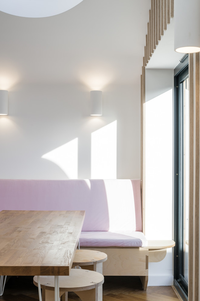 Idee per una sala da pranzo aperta verso il soggiorno chic di medie dimensioni con pareti bianche, pavimento in legno massello medio e pavimento marrone