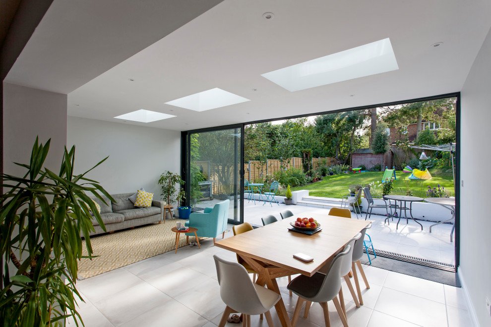 Mittelgroße Moderne Wohnküche ohne Kamin mit weißer Wandfarbe, Porzellan-Bodenfliesen und grauem Boden in Surrey