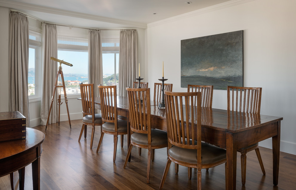 This is an example of a traditional dining room in San Francisco with white walls and dark hardwood flooring.