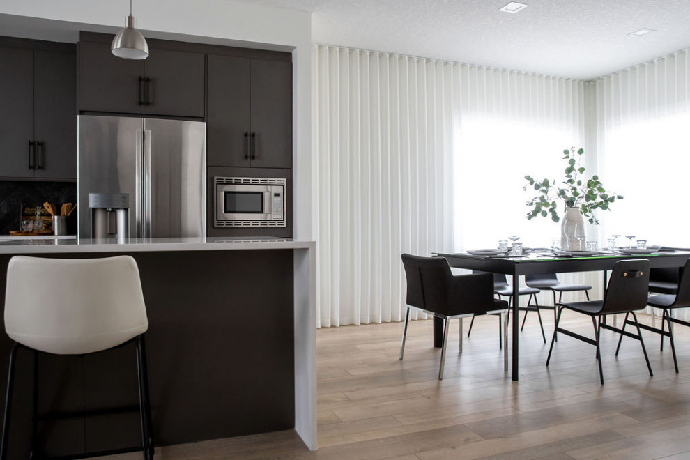 Foto di una piccola sala da pranzo aperta verso la cucina moderna con pareti bianche e pavimento in legno massello medio