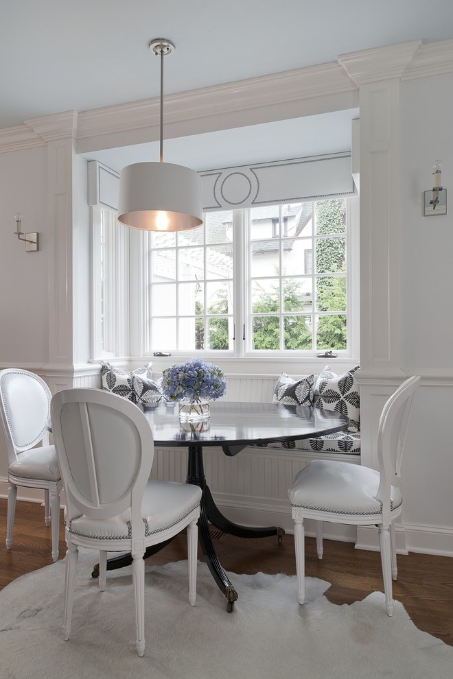 Example of a small classic medium tone wood floor kitchen/dining room combo design in New York with white walls and no fireplace