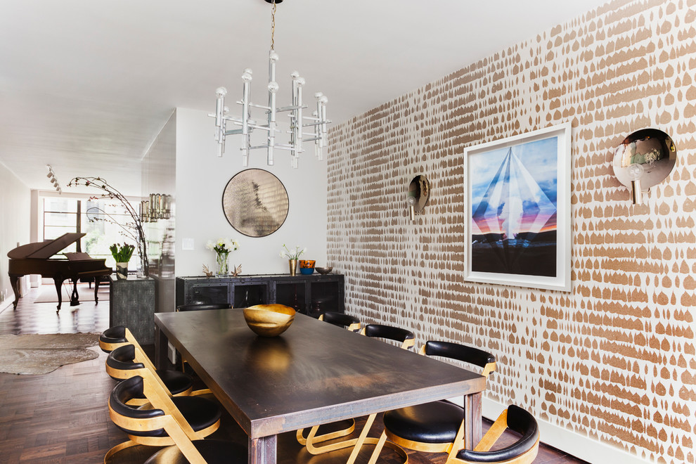 Cette photo montre une salle à manger ouverte sur le salon chic de taille moyenne avec mur métallisé, parquet foncé, aucune cheminée et un sol marron.