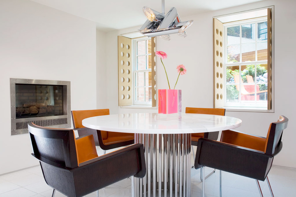 Trendy dining room photo in New York with white walls and a standard fireplace