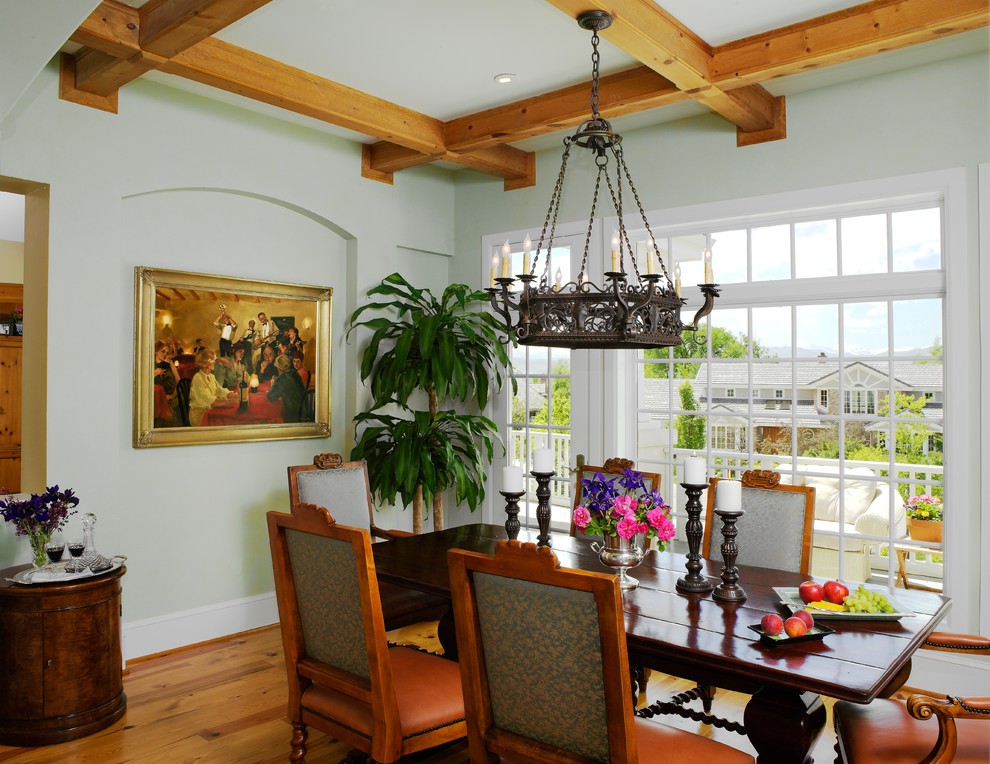 Exemple d'une salle à manger chic avec un mur vert et un sol en bois brun.