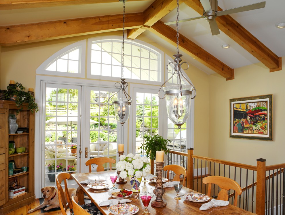 Idées déco pour une salle à manger classique avec un mur jaune, un sol en bois brun et une banquette d'angle.
