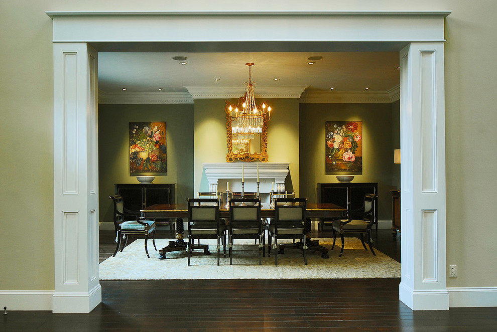Esempio di una grande sala da pranzo classica chiusa con pareti verdi, parquet scuro, camino classico, cornice del camino in legno e pavimento marrone