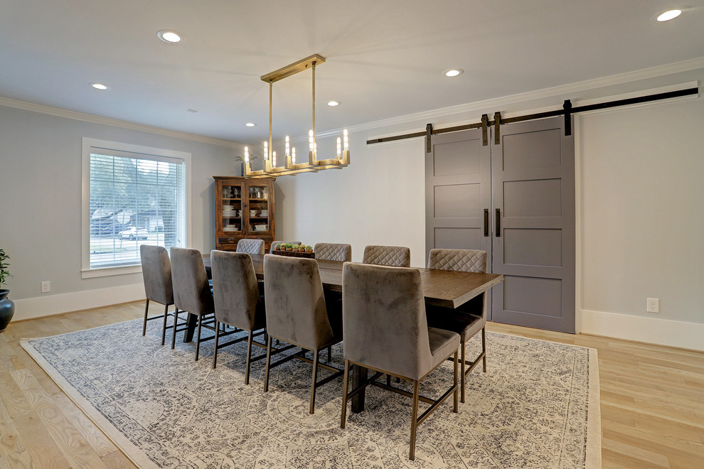 Example of a mid-sized transitional light wood floor and beige floor enclosed dining room design in Houston with gray walls