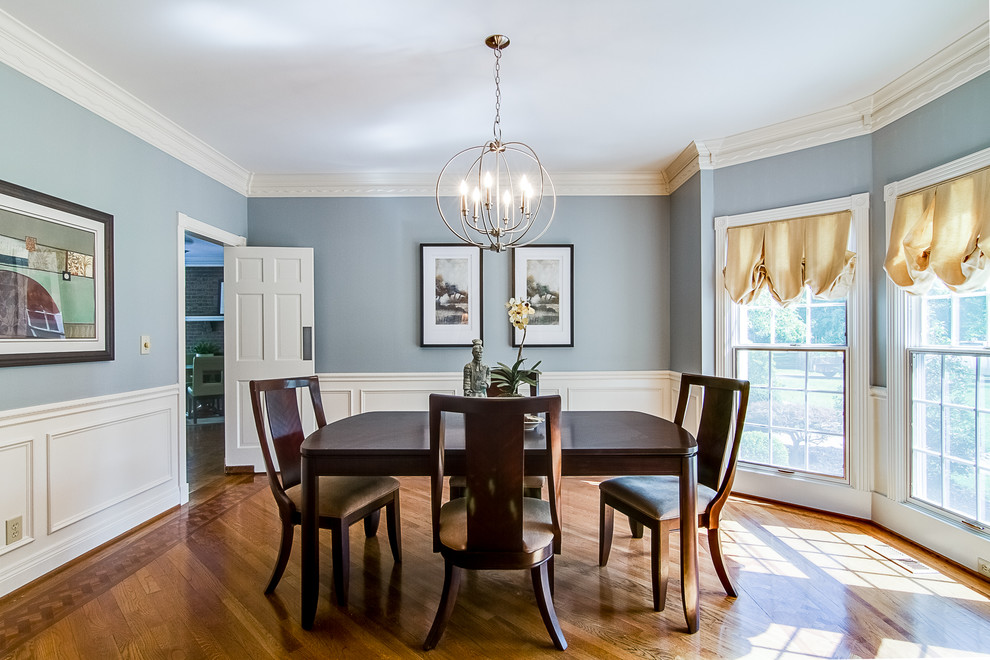 Inspiration for a large timeless medium tone wood floor and brown floor enclosed dining room remodel in Louisville with blue walls and no fireplace