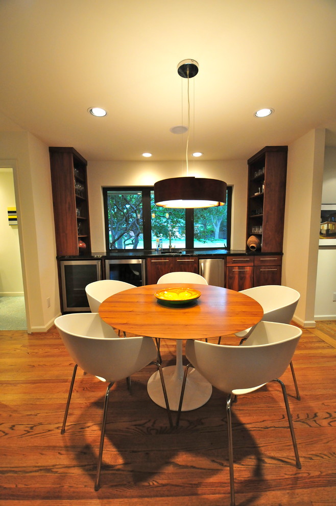 Contemporary dining room in Dallas with beige walls and dark hardwood flooring.
