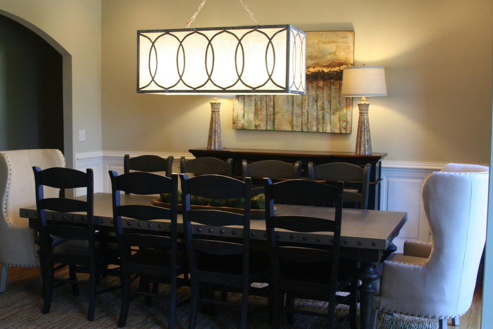 Exemple d'une salle à manger tendance fermée et de taille moyenne avec un mur beige, un sol en bois brun, un sol marron et éclairage.
