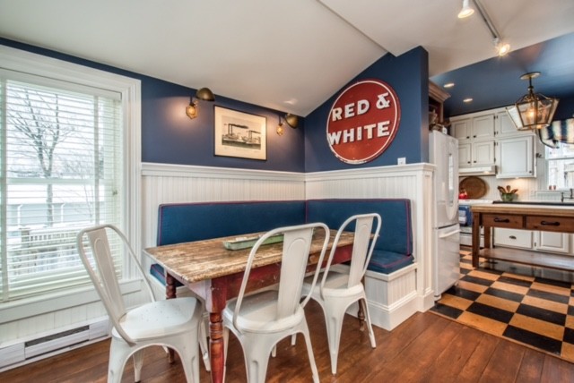 Ispirazione per una sala da pranzo aperta verso la cucina classica di medie dimensioni con pareti blu, pavimento in legno massello medio, nessun camino e pavimento marrone