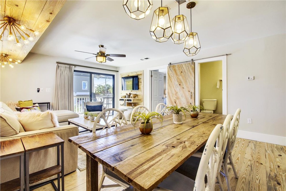 Imagen de comedor de estilo de casa de campo de tamaño medio abierto sin chimenea con paredes grises, suelo de madera en tonos medios y suelo marrón