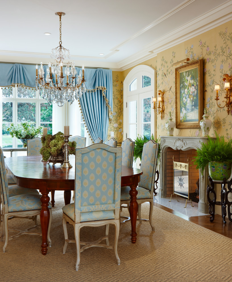 This is an example of a traditional dining room in Detroit with yellow walls and a standard fireplace.