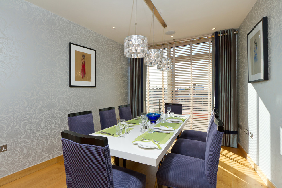 Contemporary enclosed dining room in London with grey walls and medium hardwood flooring.