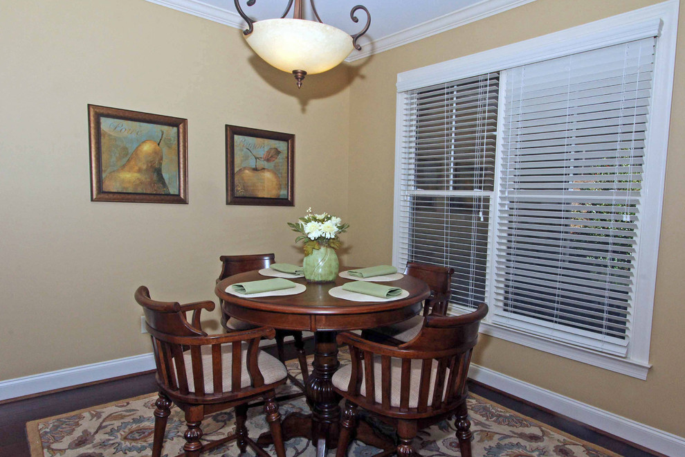 Photo of a small traditional dining room in Columbus with beige walls, dark hardwood flooring, no fireplace and brown floors.