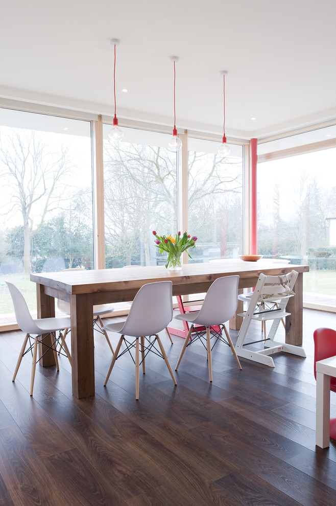 Inspiration for a contemporary dining room in London with dark hardwood flooring.