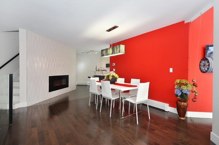 Foto di una sala da pranzo aperta verso la cucina contemporanea di medie dimensioni con pareti rosse e pavimento in legno massello medio