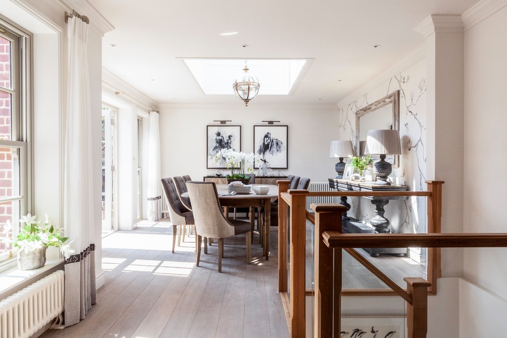 Photo of a farmhouse dining room in Surrey with medium hardwood flooring and feature lighting.