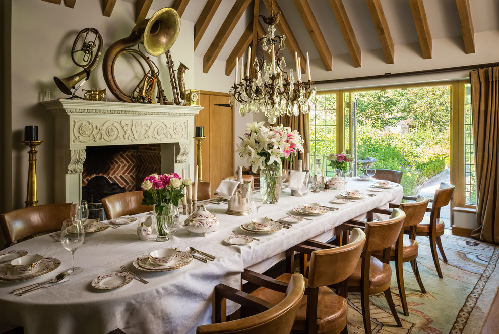 Cette image montre une salle à manger traditionnelle avec un mur beige, une cheminée standard et un manteau de cheminée en plâtre.