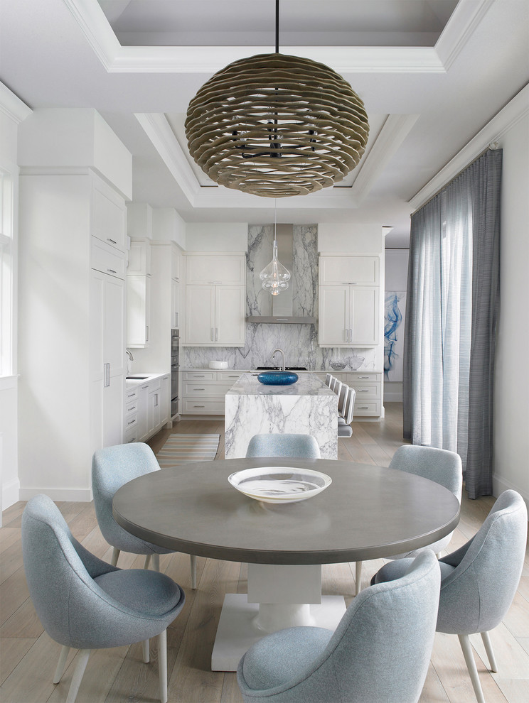 Inspiration pour une salle à manger ouverte sur la cuisine minimaliste de taille moyenne avec un mur blanc, parquet clair, aucune cheminée et un sol beige.