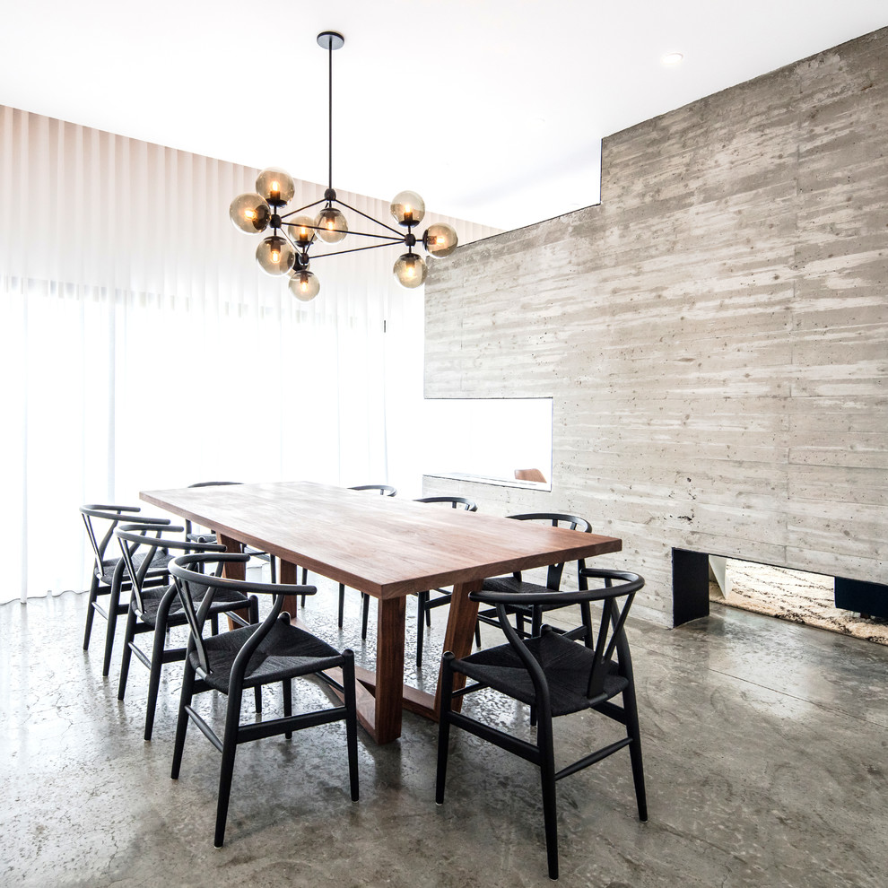 Immagine di una sala da pranzo moderna con pareti grigie, pavimento in cemento e pavimento grigio