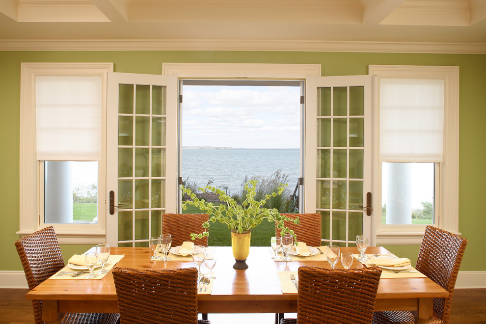 Cette image montre une salle à manger ouverte sur la cuisine traditionnelle de taille moyenne avec un mur vert et un sol en bois brun.
