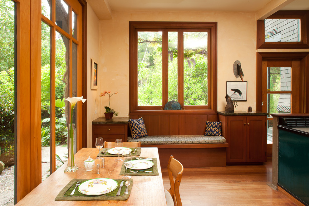 Exemple d'une salle à manger craftsman avec un mur beige et un sol en bois brun.