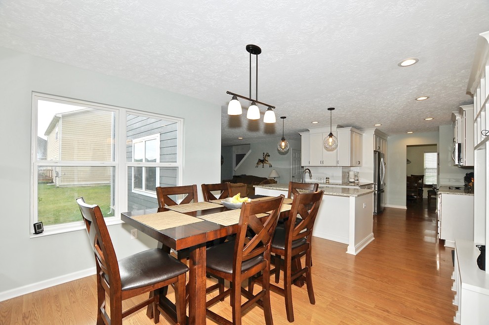 На фото: кухня-столовая среднего размера в современном стиле с серыми стенами и светлым паркетным полом с