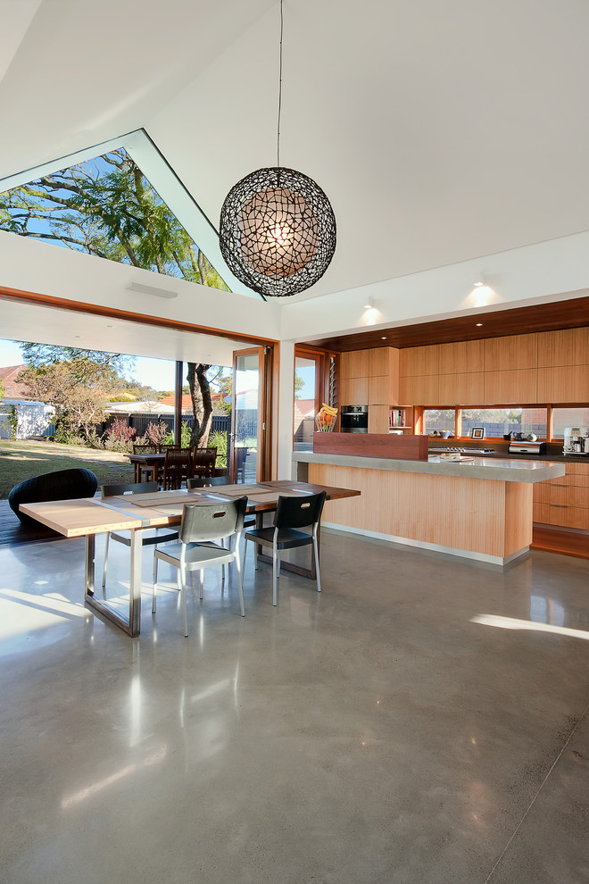 Стильный дизайн: кухня-столовая в современном стиле с белыми стенами и бетонным полом - последний тренд