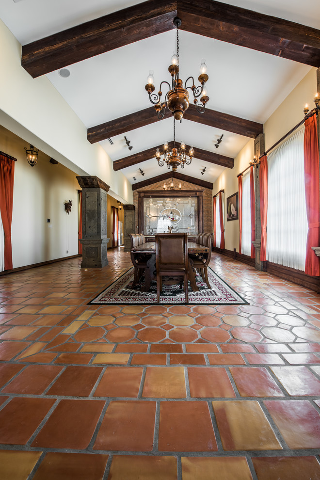 Esempio di un'ampia sala da pranzo aperta verso il soggiorno stile rurale con pareti beige, pavimento in terracotta e nessun camino