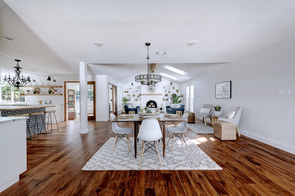 Foto di una sala da pranzo aperta verso il soggiorno country con pareti bianche, pavimento in legno massello medio e pavimento marrone