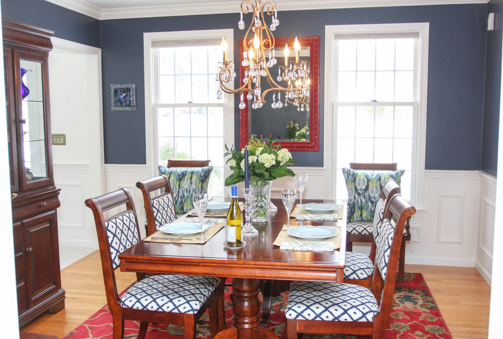 Idées déco pour une salle à manger classique avec un mur bleu et un sol en bois brun.