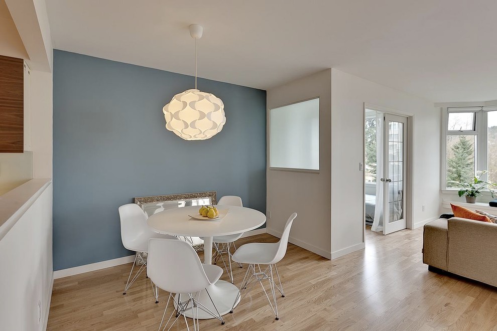 Modernes Esszimmer mit blauer Wandfarbe und braunem Holzboden in Vancouver