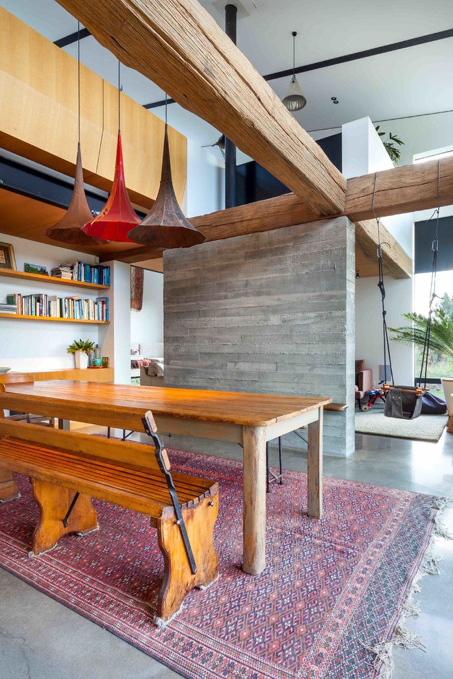 Idee per una sala da pranzo aperta verso il soggiorno design con pareti marroni e pavimento in cemento