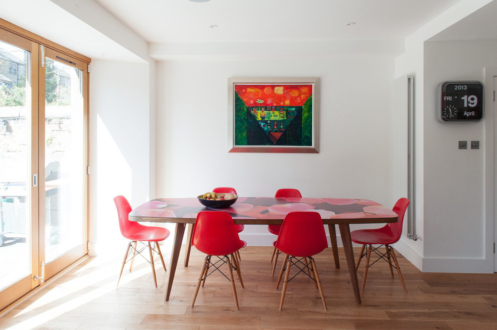 Midcentury dining room in Glasgow with white walls and medium hardwood flooring.