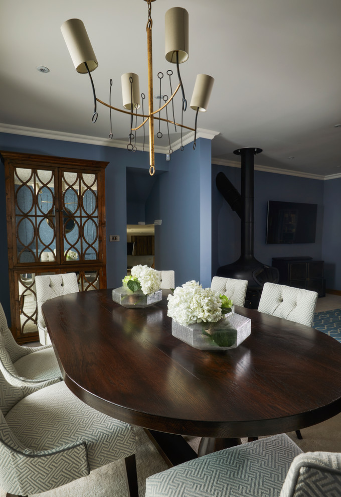 Idées déco pour une salle à manger ouverte sur le salon classique avec un mur bleu, moquette, cheminée suspendue et un manteau de cheminée en métal.