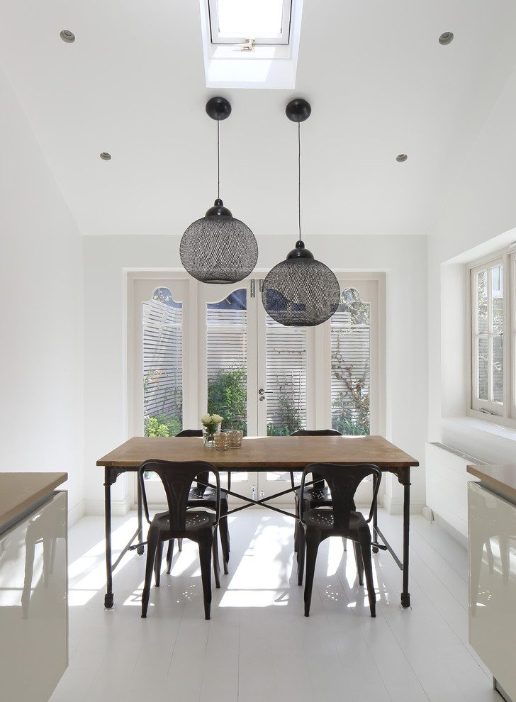 На фото: кухня-столовая среднего размера в современном стиле с белыми стенами и полом из керамической плитки без камина