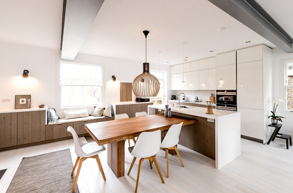 Foto di una sala da pranzo aperta verso la cucina design con pareti bianche, pavimento in legno verniciato e pavimento bianco