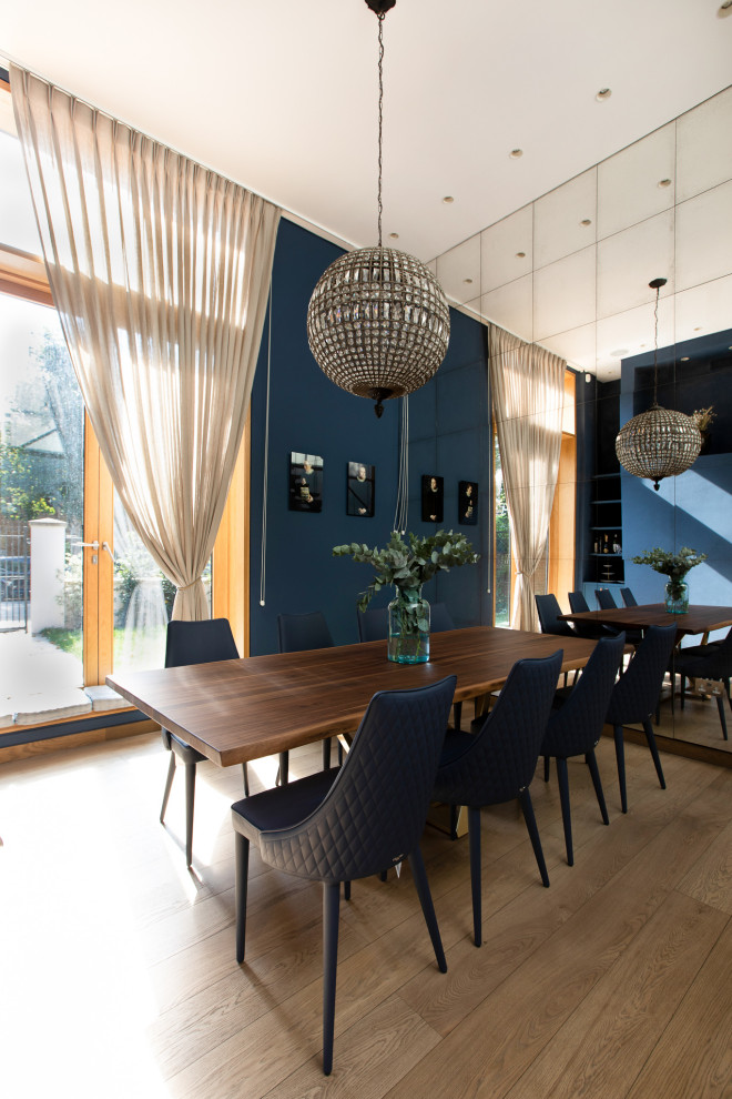 Imagen de comedor minimalista de tamaño medio cerrado sin chimenea con paredes azules, suelo de madera clara, suelo beige y casetón