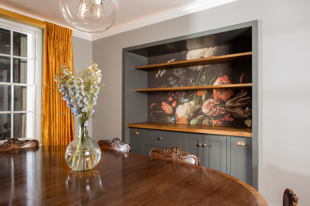 Photo of a medium sized traditional dining room in London with banquette seating, medium hardwood flooring and wood walls.