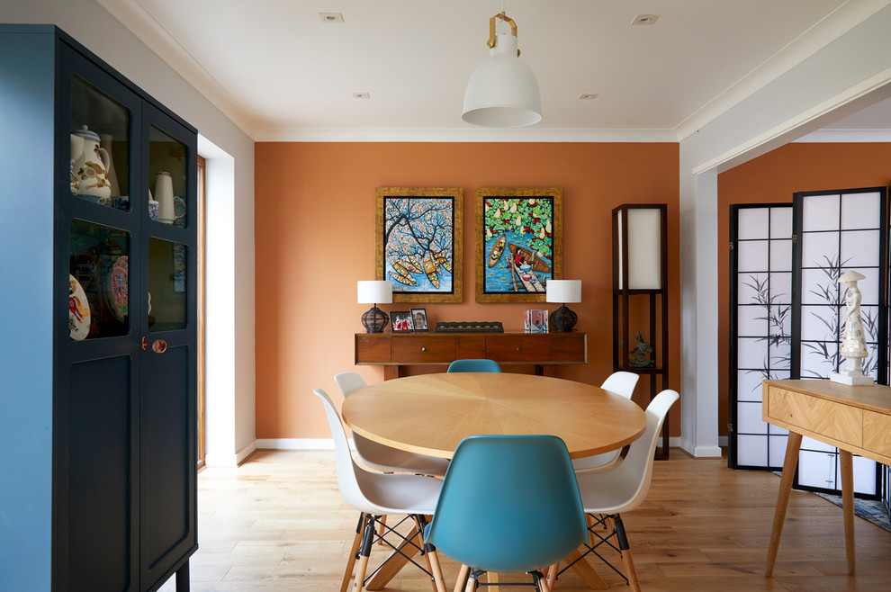 Klassische Wohnküche mit oranger Wandfarbe, braunem Holzboden und braunem Boden in London