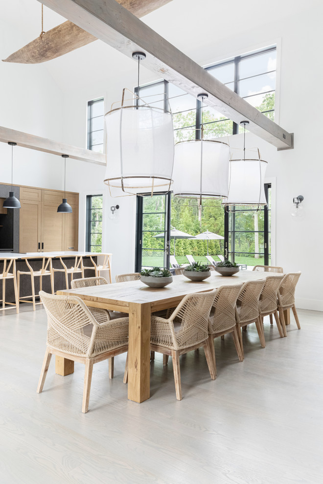 Esempio di una sala da pranzo aperta verso la cucina costiera di medie dimensioni con pareti bianche, parquet scuro e pavimento grigio