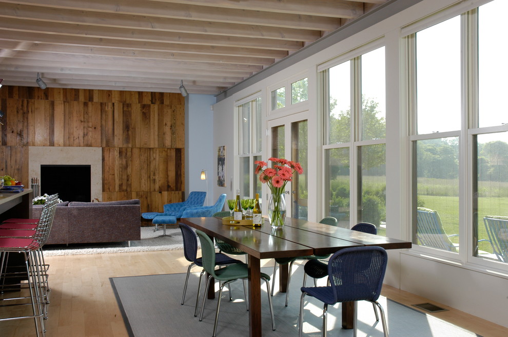 Immagine di una sala da pranzo aperta verso il soggiorno country con pavimento in legno massello medio