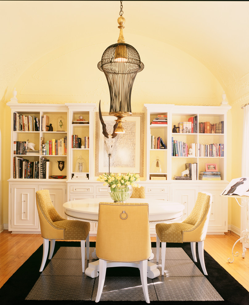 Idées déco pour une salle à manger classique avec un mur jaune et un sol en bois brun.