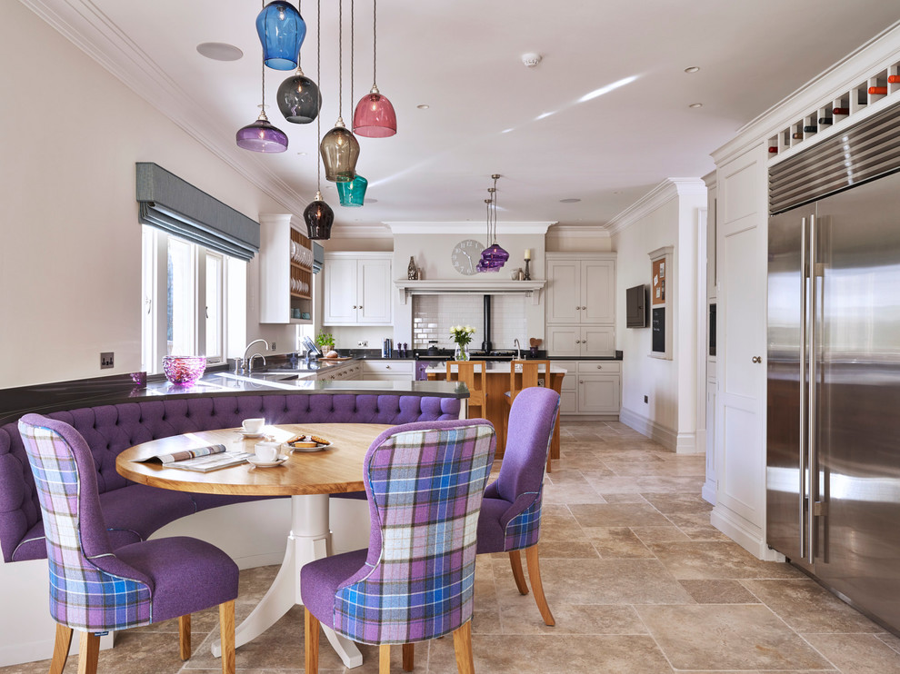 Immagine di una grande sala da pranzo aperta verso la cucina classica con pavimento in pietra calcarea, pavimento beige e pareti beige