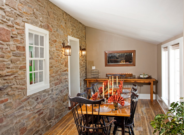 Foto di una piccola sala da pranzo aperta verso la cucina country con pareti grigie e pavimento in legno massello medio