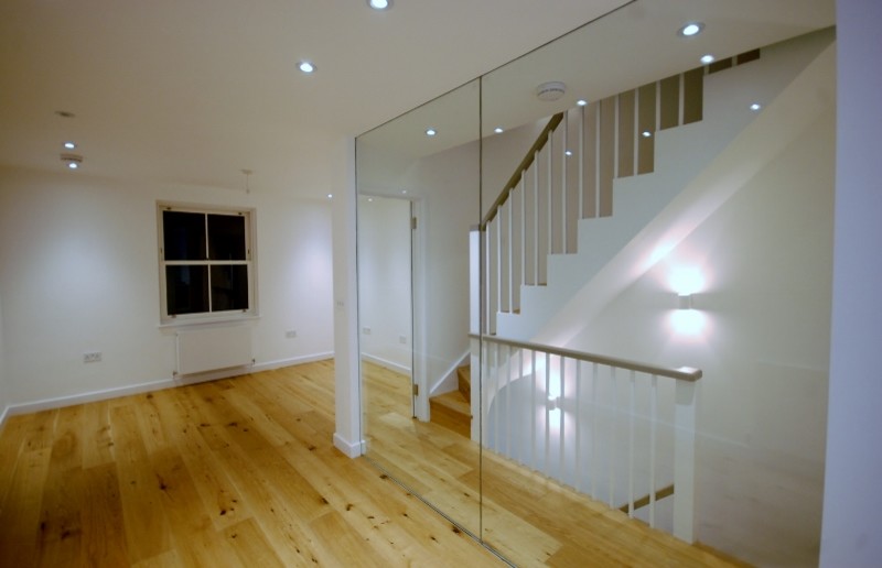 Photo of a small contemporary open plan dining room in London with white walls and light hardwood flooring.