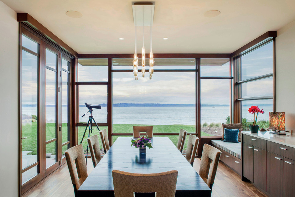 Ispirazione per una sala da pranzo aperta verso la cucina contemporanea con pareti beige e pavimento in legno massello medio